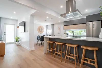 a kitchen with a counter and bar stools at 5BR HotTubPoolTableMiniGolf 7 min to Wynwood in Miami