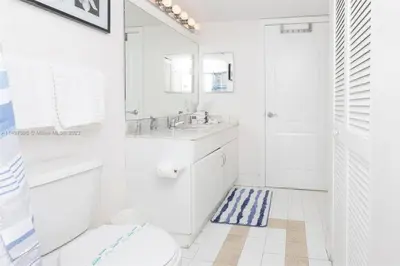 a bathroom with a sink and a toilet and a mirror at Entire Condo in Brickell steps from Brickell City Centre in Miami