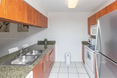 a kitchen with a sink and a stainless steel refrigerator at Entire Condo in Brickell steps from Brickell City Centre in Miami