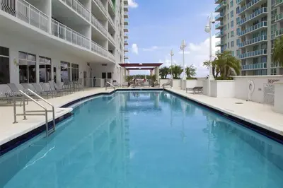 a large swimming pool with chairs and a building at Entire Condo in Brickell steps from Brickell City Centre in Miami