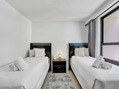two beds in a white room with a window at Cozy Beachfront 2 BDR Miami Beach Condo 1516 in Miami Beach