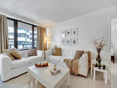 a white living room with a white couch and a table at Cozy Beachfront 2 BDR Miami Beach Condo 1516 in Miami Beach