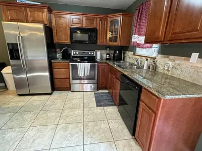 a kitchen with wooden cabinets and stainless steel appliances at 2 Bedroom Boutique Gem 10 min to the beach Washer Dryer Gated Parking Bliss 2 in Hollywood