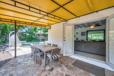 a patio with a table and chairs and a pool at Modern Tropical Pool House North Miami Hot Tub in Miami