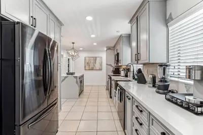 a large kitchen with white counters and stainless steel appliances at Miami Oasis, Spacious 4-Bedroom Home with Pool in Miami