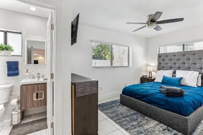 a bedroom with a blue bed and a bathroom at Miami Oasis, Spacious 4-Bedroom Home with Pool in Miami