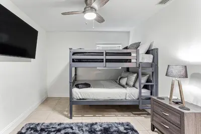 a bedroom with a bunk bed with a tv and a couch at Miami Oasis, Spacious 4-Bedroom Home with Pool in Miami