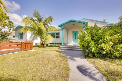 a house with a palm tree in front of it at Near Haulover Park Hollywood Cottage with Yard! in Hollywood