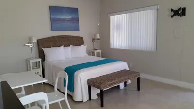 a bedroom with a bed and a chair and a window at Hollywood Broadwalk Oceanside Hotel in Hollywood