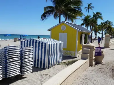 a small shack on a beach with palm trees and the ocean at Hollywood Broadwalk Oceanside Hotel in Hollywood