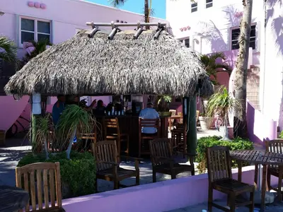 a restaurant with tables and chairs and a straw umbrella at Hollywood Broadwalk Oceanside Hotel in Hollywood