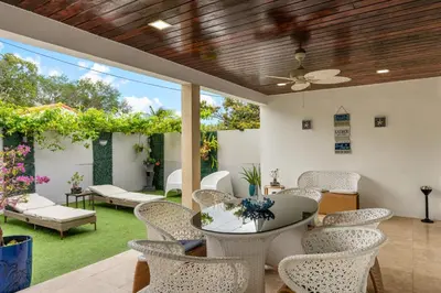 an outdoor patio with a table and chairs and a ceiling at D'Mauchi House in Miami