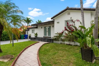 a house with palm trees and a walkway at D'Mauchi House in Miami