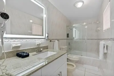 a bathroom with a sink and a toilet and a mirror at D'Mauchi House in Miami