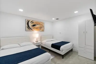 a bedroom with two beds and a painting on the wall at D'Mauchi House in Miami
