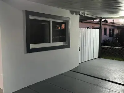 a white wall with a window on the side of a house at Adrien Guest Studio in Miami Gardens