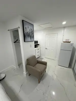 a living room with a chair and a kitchen at Adrien Guest Studio in Miami Gardens