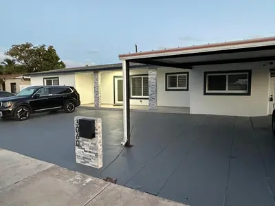 a car parked in a parking lot next to a house at Adrien Guest Studio in Miami Gardens