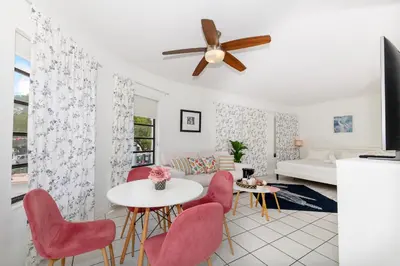 a living room with a ceiling fan and a table and chairs at Art Deco Washingthon Apartment in Miami Beach
