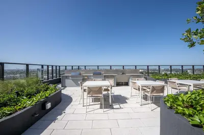 a patio with tables and chairs and the ocean in the background at Blueground Wynwood gym roof pool nr Midtown MIA-101 in Miami