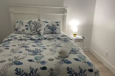 a bed with a blue and white blanket and pillows at Cozy newly furnished apartment , on the 6th floor. in Sunny Isles Beach