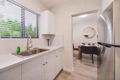 a kitchen with a stainless steel refrigerator and a table at Prime Location Apartment at Calle Ocho in Miami
