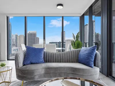 a living room with a couch and large windows at X Lounge IV-Skyline Corner Residence in Miami