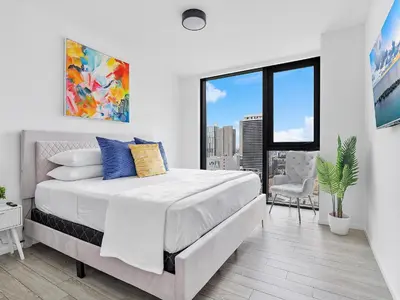 a white bedroom with a bed and a large window at X Lounge IV-Skyline Corner Residence in Miami