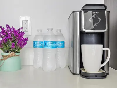 a group of bottles of water next to a coffee maker at X Lounge IV-Skyline Corner Residence in Miami