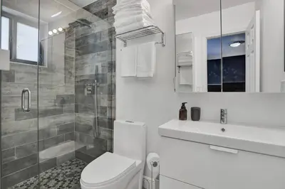 a white bathroom with a toilet and a shower at Casa Coral with Pool Charcoal BBQ area in Miami