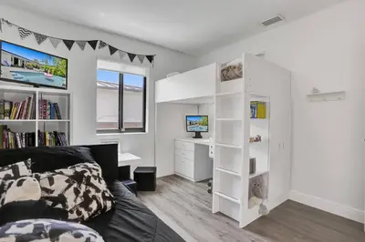 a bedroom with a bed and a desk with a computer at Casa Coral with Pool Charcoal BBQ area in Miami