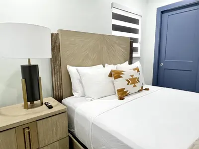 a bedroom with two beds and a blue door at Renovated Grand Villa Paradise Amazing pool, BBQ & Ping Pong in Tamiami