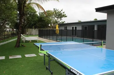 a ping pong table in a yard with a pool at Sunny Resort Oasis with Heated Pool Ping Pong in Tamiami
