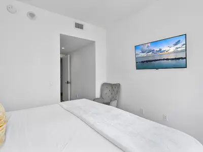 a white bedroom with a bed and a picture on the wall at X Lounge-Contemporary Corner Residence in Miami