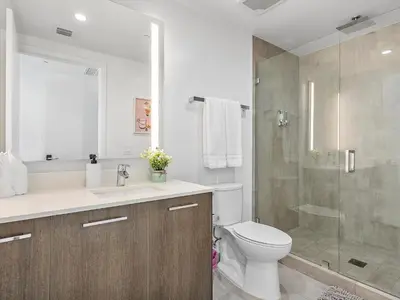 a bathroom with a toilet and a glass shower at X Lounge-Contemporary Corner Residence in Miami