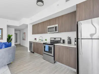 a kitchen with a stainless steel refrigerator and wooden cabinets at X Lounge-Contemporary Corner Residence in Miami