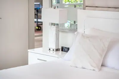 a white bed with a white lamp and a pillow at Tropical Waterfront Family Oasis - Amazing Location in Miami