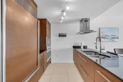 a kitchen with wooden cabinets and a sink at Lovely 1BR W Icon Brickell-FREE SPA in Miami
