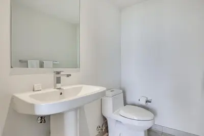 a white bathroom with a sink and a toilet at Walk to Hollywood Beach Upscale 16th-Floor Condo in Hollywood