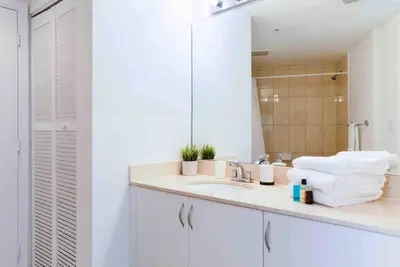 a white bathroom with a sink and a mirror at Beautiful apartment Miami, FL in Miami