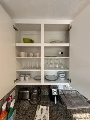 a kitchen with white shelves with cups and dishes at Deluxe Room in best location Miami in a 2 Bedrooms Unit - Parking, Laundry and Luggage Storage in Miami