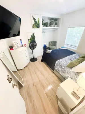 a bedroom with a bed and a flat screen tv at Deluxe Room in best location Miami in a 2 Bedrooms Unit - Parking, Laundry and Luggage Storage in Miami