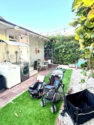 a garden with two strollers sitting on the grass at Deluxe Room in best location Miami in a 2 Bedrooms Unit - Parking, Laundry and Luggage Storage in Miami