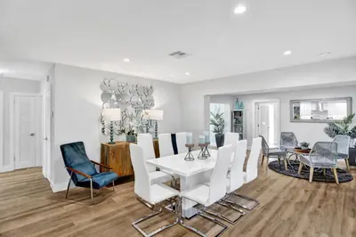 a dining room with a white table and chairs at Modern home w heated pool canal views in Hollywood