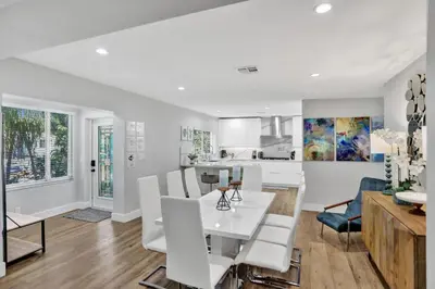 a kitchen and living room with a white table and chairs at Modern home w heated pool canal views in Hollywood