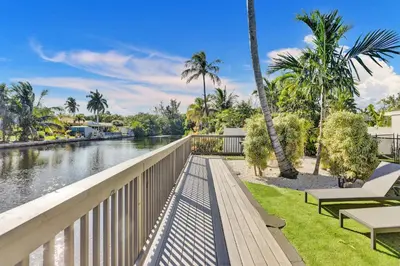 a bridge over a river with palm trees at Modern home w heated pool canal views in Hollywood