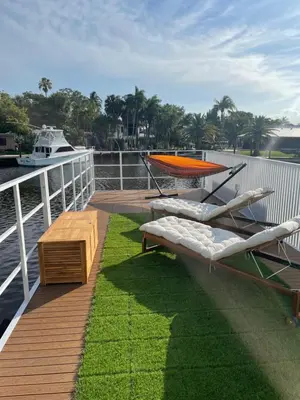a deck with lounge chairs and a table on a boat at Unique Houseboat Modern and New in Fort Lauderdale