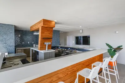 a kitchen with a counter with stools at High Style Living in the Heart of Miami in Miami