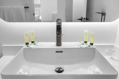 a bathroom sink with two glasses and a faucet at High Style Living in the Heart of Miami in Miami