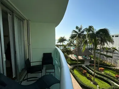 a balcony of a hotel with two chairs and palm trees at Tropical ocean view 1 bedroom in Hollywood